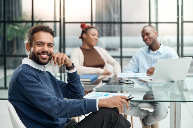 Smiling businessman sitting near the office desk