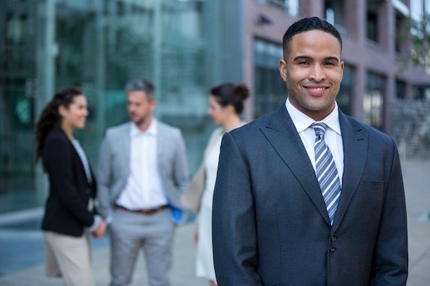 Smiling businessman standing at office building