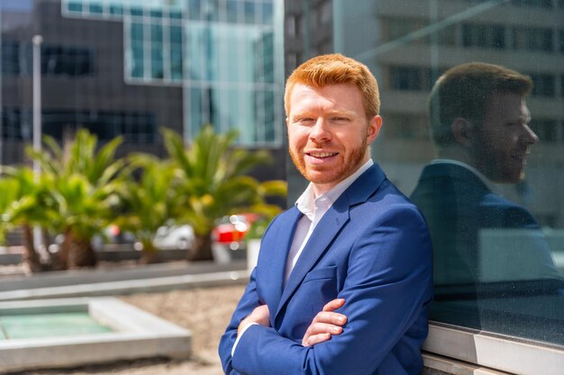 Smiling businessman standing proud with arms crossed outdoors