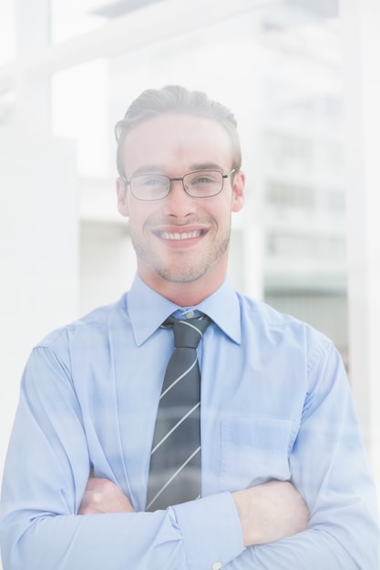 Smiling businessman standing with arms crossed