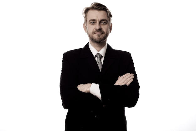 Smiling businessman standing with arms folded isolated