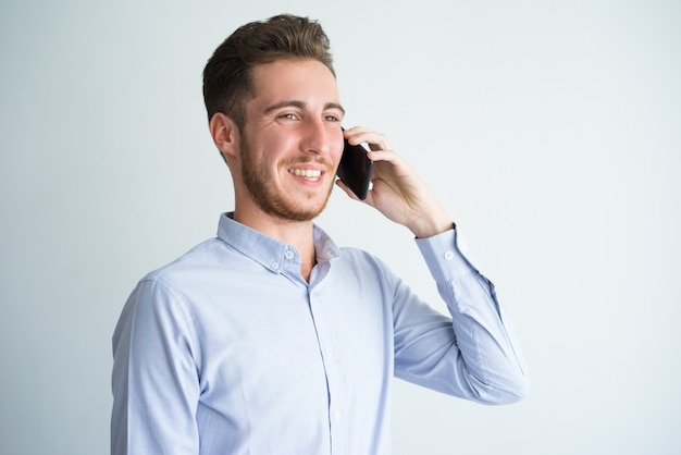 Улыбаясь бизнесмен говорить по мобильному телефону