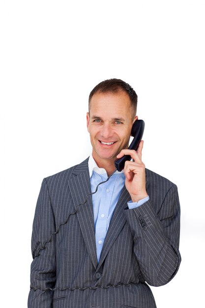 Smiling businessman tangled up in phone wires 