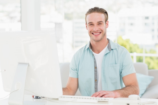 Smiling businessman typing on keyboard