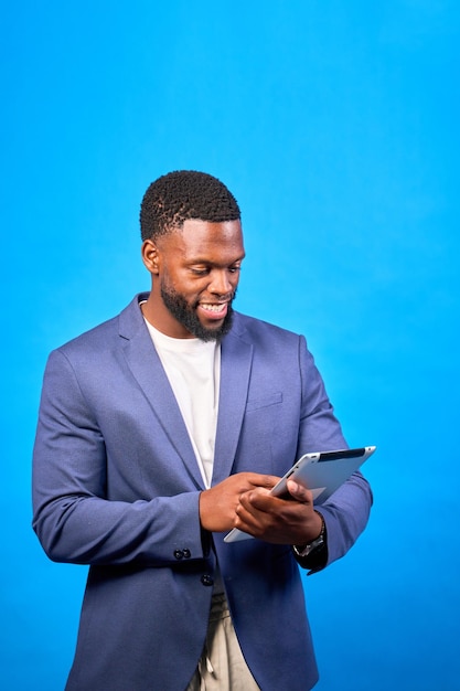 smiling businessman using digital tablet on blue background