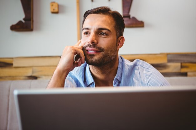 Smiling businessman using his laptop