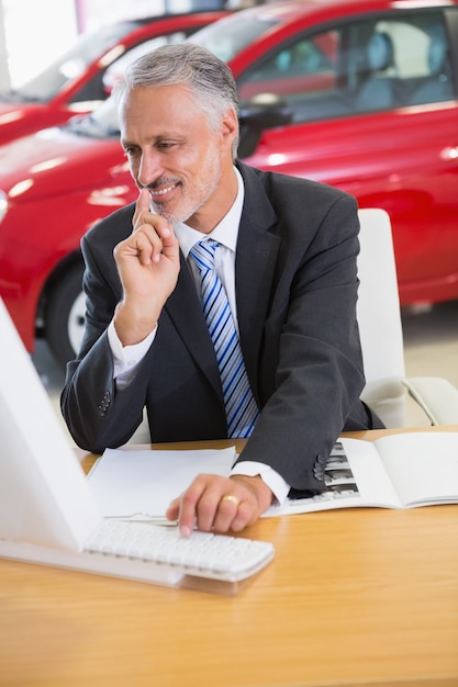 Smiling businessman using his laptop