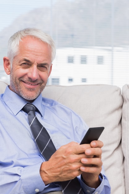 Smiling businessman using smartphone