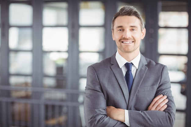 Smiling businessman with arms crossed in office