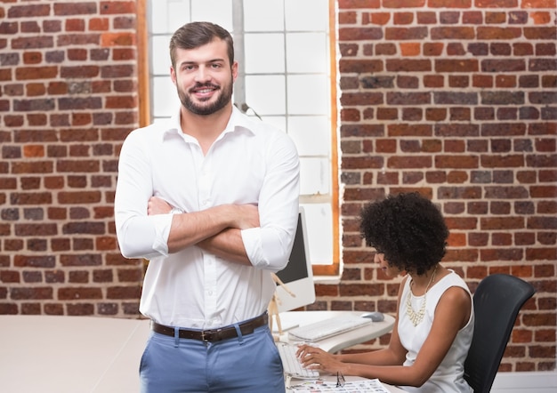 Smiling businessman with arms crossed in office