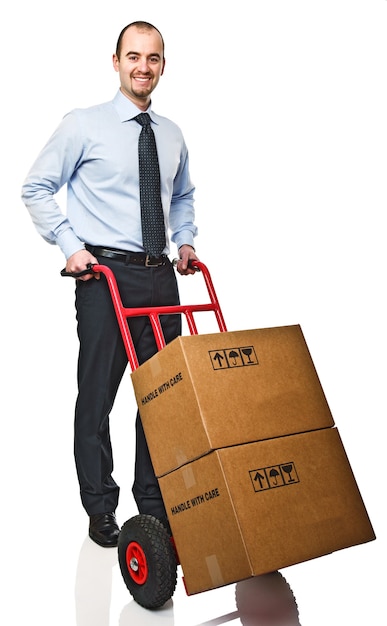 Smiling businessman with red handtruck and boxes