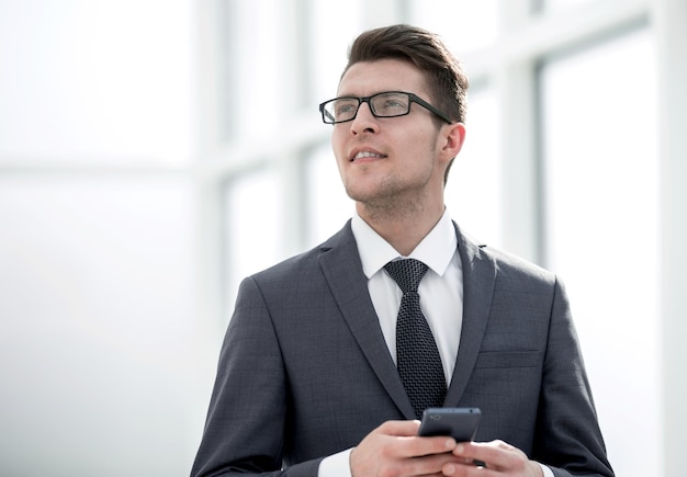 Smiling businessman with smartphone photo with copy space