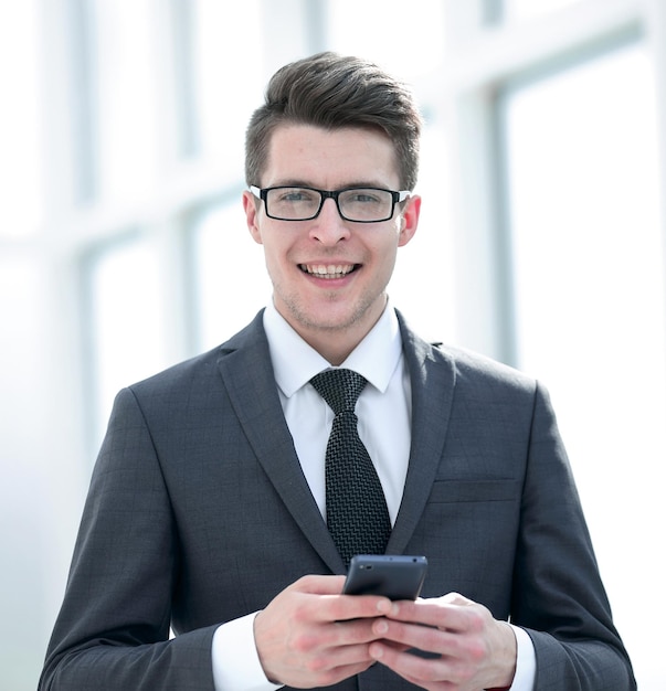 Smiling businessman with smartphone photo with copy space