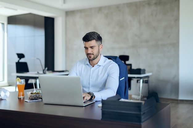 Smiling businessman working on a computer at his office desk