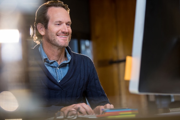 Smiling businessman working on computer