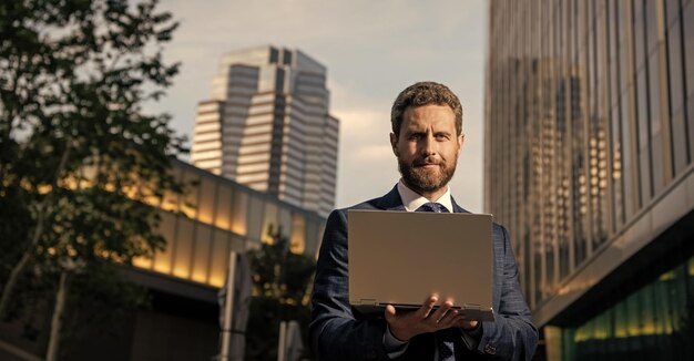 Smiling businessperson communicating online on computer outside the office business