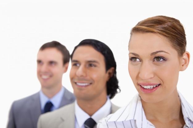 Foto businessteam sorridente che si leva in piedi in una riga che sembra giusta