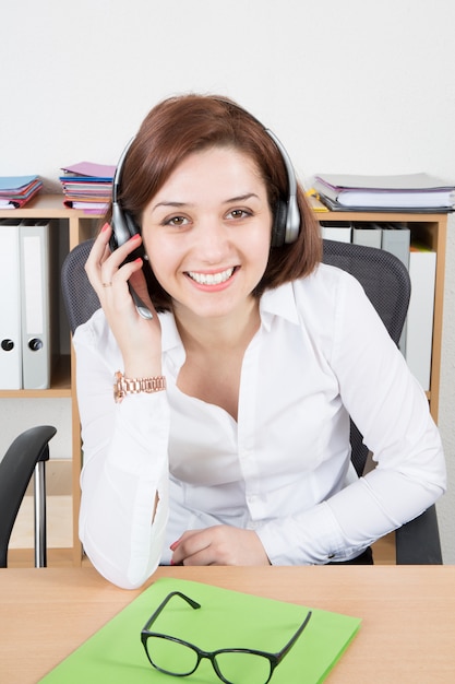Foto donna di affari sorridente nella call center con la cuffia di sostegno