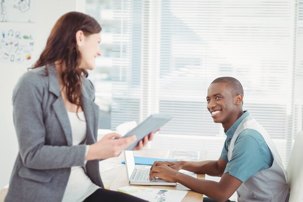 Smiling businesswoman discussing with man 