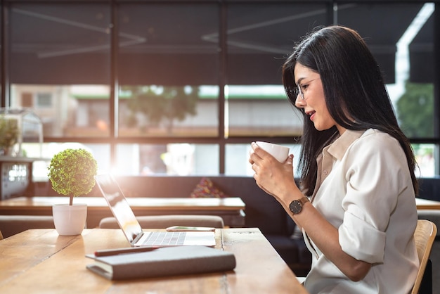 smiling businesswoman drinking coffee on table
