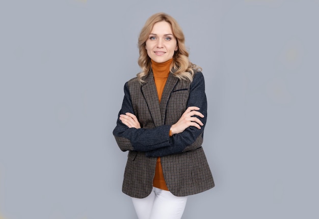 Smiling businesswoman in english clothes on grey background cheerful blonde woman in jacket female beauty and fashion business casual style girl in british jacket british fashion style