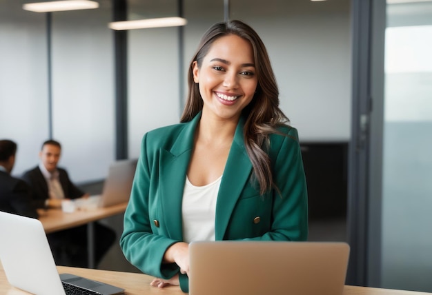 Smiling businesswoman in green blazer at her workstation