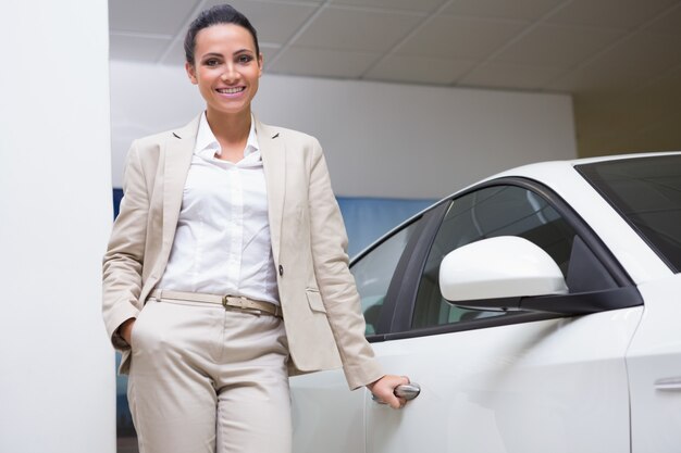 Smiling businesswoman holding a car door handles