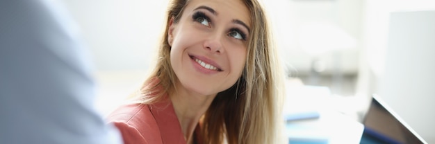 Smiling businesswoman holding stylus male colleague holds out her tablet