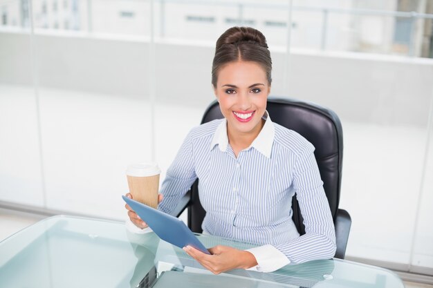 Photo smiling businesswoman holding tablet and disposable cup