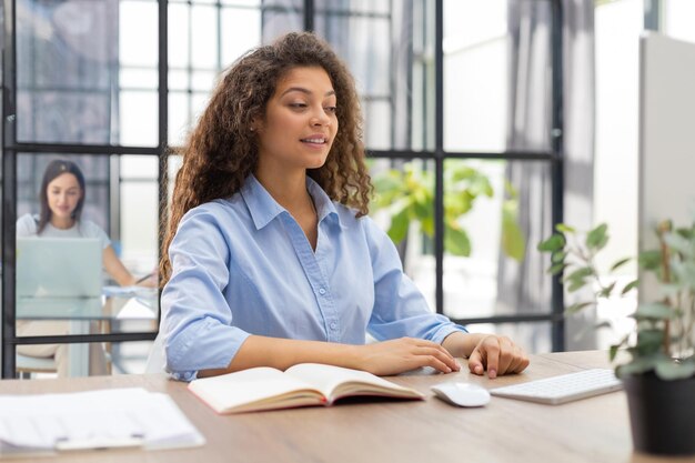 Smiling businesswoman looking at camera make conference or\
business call recording video blog talking with client collegue is\
on the background