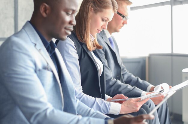 smiling businesswoman looking at camera at seminar with her colleagues near by