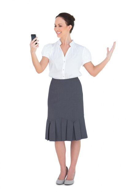 Smiling businesswoman looking at her phone