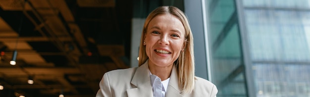 Smiling businesswoman making notes and talks to camera while working in cafe