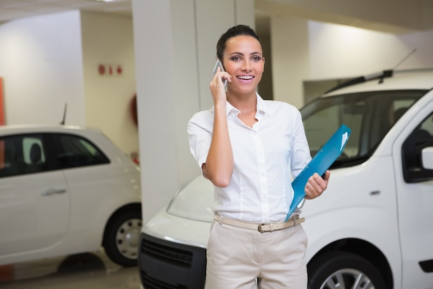 Smiling businesswoman on the phone holding folder