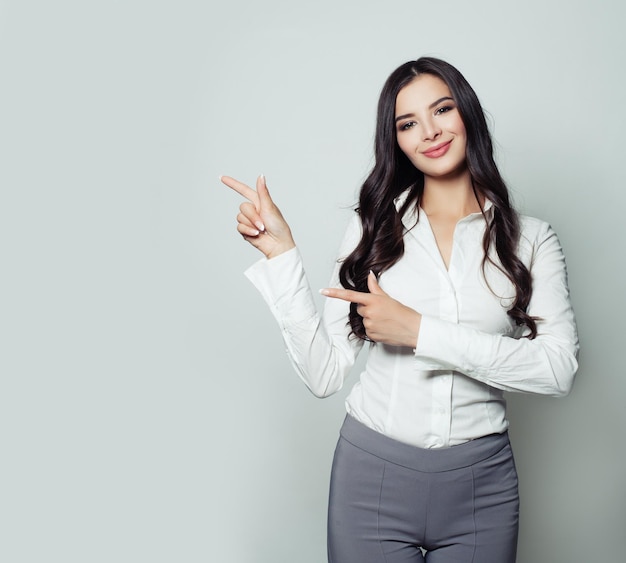 Smiling businesswoman pointing her finger to empty copy space for advertising marketing or product placement Confident business woman portrait