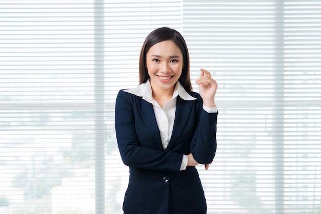 Smiling businesswoman portrait in office standing by window