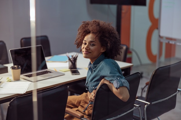 Smiling businesswoman sitting on the chair in the office