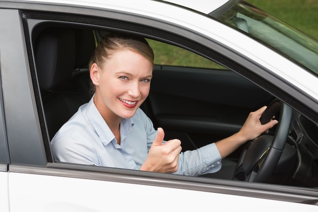 Donna di affari sorridente che si siede nel sedile dei driver