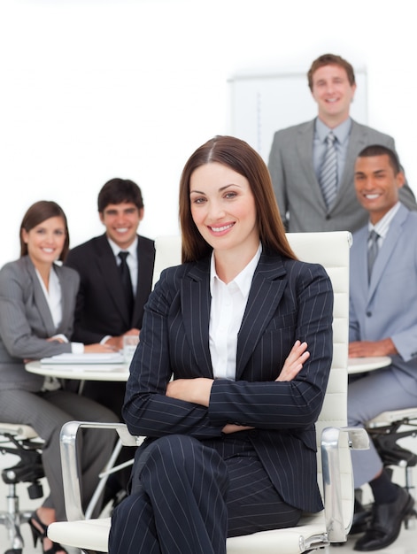 Smiling businesswoman sitting in front of her team 