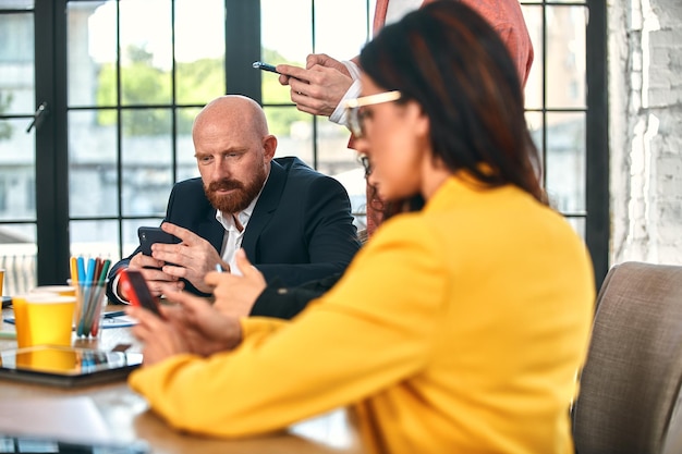 Photo smiling businesswoman smiling with telephone in a meeting with her colleagues working in the