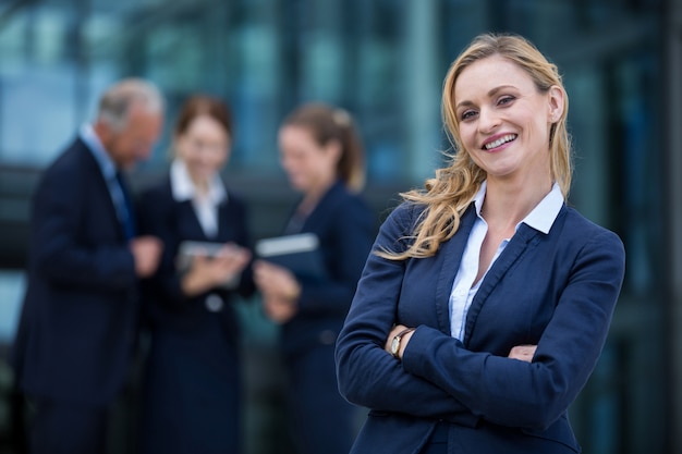 Smiling businesswoman standing with arms crossed