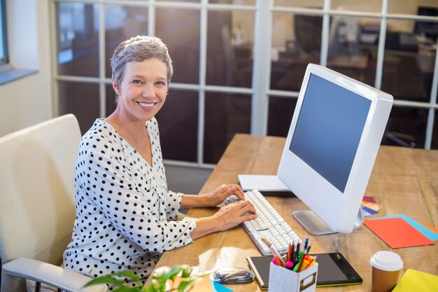 Smiling businesswoman typing on keyboard