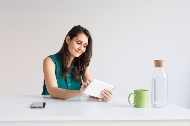 Photo smiling businesswoman using digital tablet in office