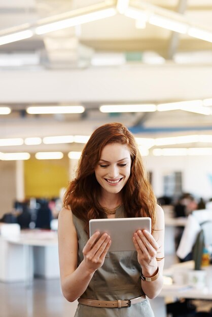 Foto una donna d'affari sorridente che usa un tablet digitale in ufficio