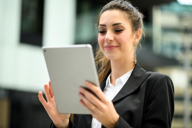 Photo smiling businesswoman using a digital tablet outdoor