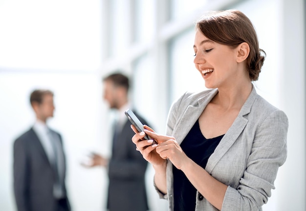 Photo smiling businesswoman using her smartphone