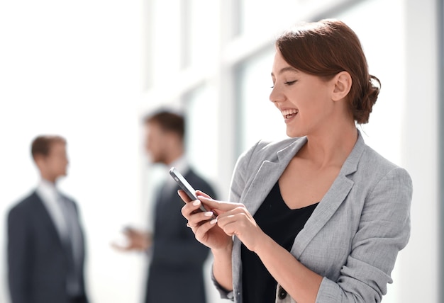 Photo smiling businesswoman using her smartphonephoto with space for text