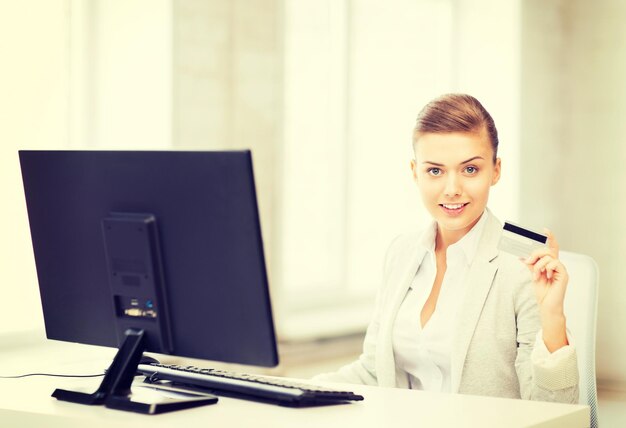 smiling businesswoman with computer using credit card