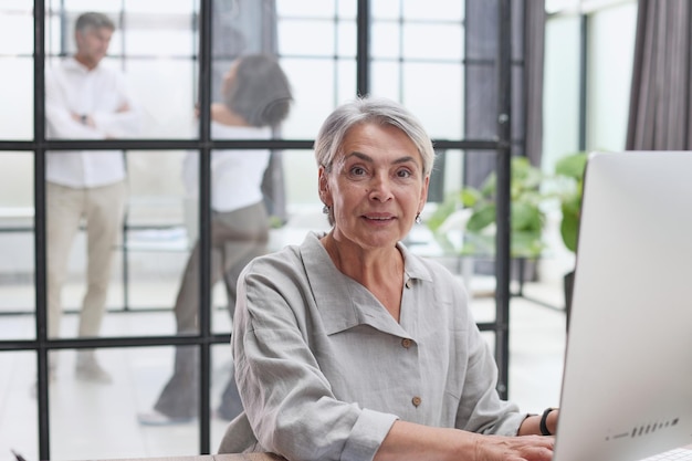 Smiling businesswoman with digital tablet listening during meeting in office