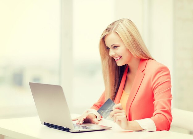 smiling businesswoman with laptop and credit card